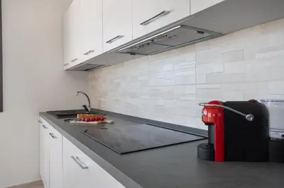a kitchen with white cabinets and a red appliance on a counter at Villa vista mare con piscina a Sarmuci in Castellammare del Golfo