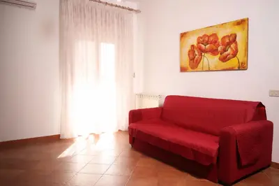 a red couch in a living room with a window at Appartamento Rebecca in Palermo