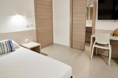 a bedroom with a bed and a desk and a chair at Kalsa Sicilian Rooms in Partinico