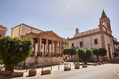 an old building with trees in front of it at Kalsa Sicilian Rooms in Partinico