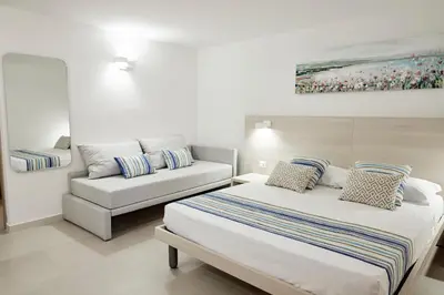 a bedroom with two beds and a couch at Kalsa Sicilian Rooms in Partinico