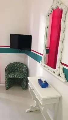 a bedroom with a bed and a mirror and a chair at Briaria Apartment in Palermo
