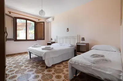 a bedroom with two beds and a window at Solemar Sicilia - Villa Corallo in Bagheria