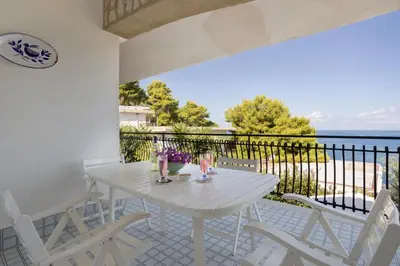 a white table and chairs on a balcony with the ocean at Solemar Sicilia - Villa Corallo in Bagheria
