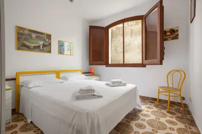 a bedroom with a bed and a window and a chair at Solemar Sicilia - Villa Corallo in Bagheria