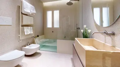 a bathroom with a sink and a toilet and a mirror at Carletta's Aparta-Suite & Spa in Palermo