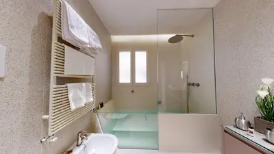 a bathroom with a glass shower and a sink at Carletta's Aparta-Suite & Spa in Palermo