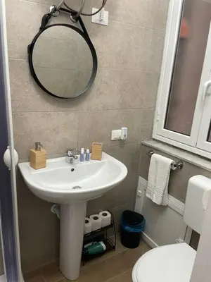 a bathroom with a sink and a mirror and a toilet at Maison L'amuri in Palermo