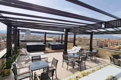 a patio with tables and chairs on a roof at Simply the best - apartment and parking space by Balsamotto in Palermo