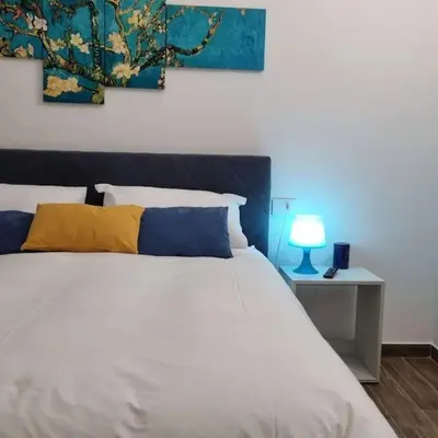 a bedroom with a white bed and a blue lamp at Simply the best - apartment and parking space by Balsamotto in Palermo