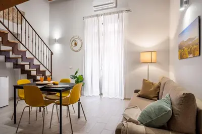 a living room with a couch and a table and chairs at Open Sicily Homes - Near the Central Train Station in Palermo