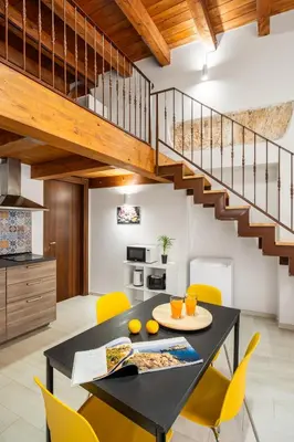a kitchen and dining room with a black table and yellow chairs at Open Sicily Homes - Near the Central Train Station in Palermo