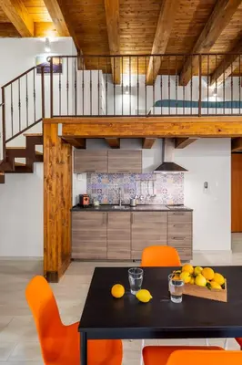 a kitchen with a black table and orange chairs at Open Sicily Homes - Near the Central Train Station in Palermo