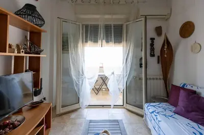 a living room with a couch and a sliding glass door at Isola delle Femmine Holiday in Isola delle Femmine