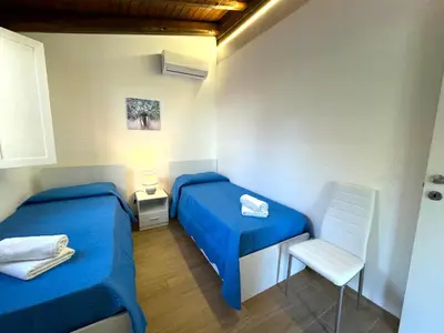 a small room with two beds and a chair at Villa Talìa in Carini