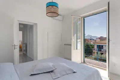 a white bedroom with a bed and a large window at Solemar Sicilia - Casa Margherita in Santa Flavia