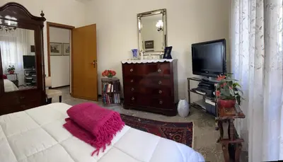 a bedroom with a bed and a tv and a mirror at Holiday & House - Imparato Palermo Centro Politeama in Palermo