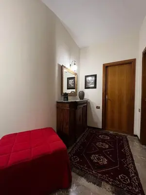 a bedroom with a red bed and a wooden door at Holiday & House - Imparato Palermo Centro Politeama in Palermo