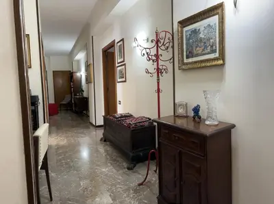 a hallway with a room with a table and a picture on the wall at Holiday & House - Imparato Palermo Centro Politeama in Palermo