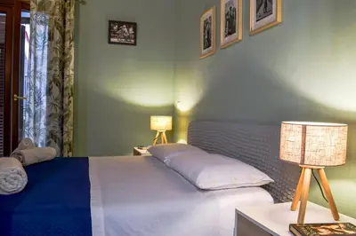 a bedroom with a bed and two lamps on a table at Happie Casa La Cattedrale in Palermo
