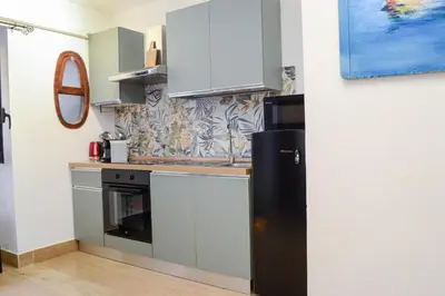 a kitchen with a black refrigerator and a wall at Happie Casa La Cattedrale in Palermo
