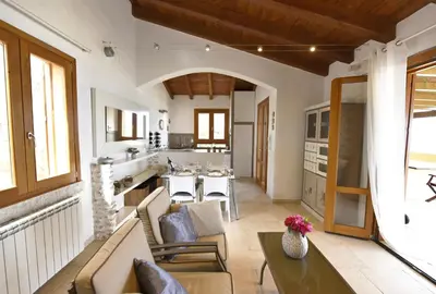 a kitchen and living room with a table and chairs at Villa Fenice in Scopello