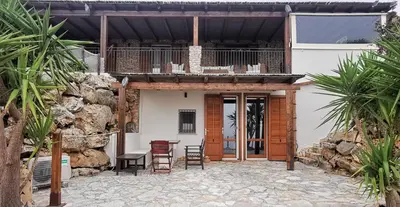 a house with a patio with a table and chairs at Villa Fenice in Scopello