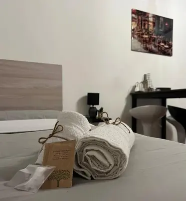 two towels on a bed with a sign on it at Central Cathedral Apartment in Palermo