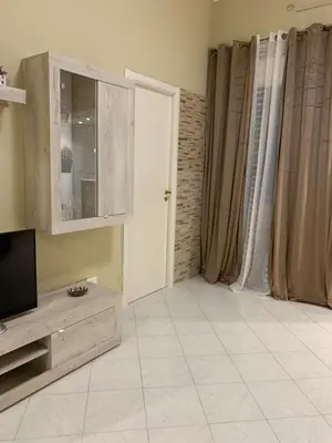 a living room with a television and a tiled floor at Casa Leila in Palermo