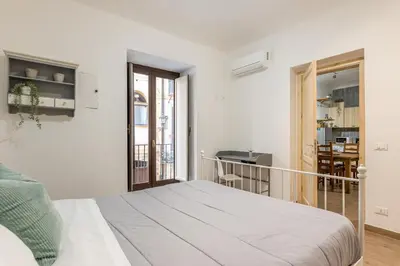 a white bedroom with a bed and a balcony at Borsa Apartments by Wonderful Italy in Palermo