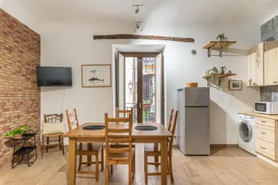 a kitchen and dining room with a table and a refrigerator at Borsa Apartments by Wonderful Italy in Palermo