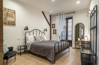 a bedroom with a bed and a chair at Borsa Apartments by Wonderful Italy in Palermo