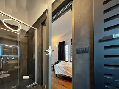 a bathroom with a glass door leading to a bedroom at Gioiamia - Luxury Rooms in Cattedrale in Palermo
