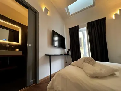 a bedroom with a bed and a television and a window at Gioiamia - Luxury Rooms in Cattedrale in Palermo