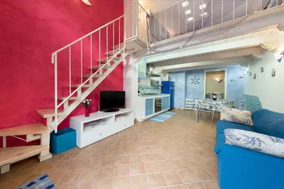 a living room with a loft with a staircase at Cambusa del Capitano in San Vito lo Capo