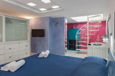 a bedroom with a blue bed with white towels at Cambusa del Capitano in San Vito lo Capo