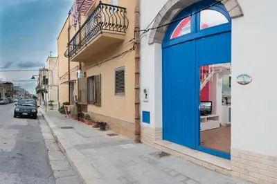 a blue door on a building on a street at Cambusa del Capitano in San Vito lo Capo