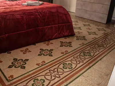a bedroom with a bed and a rug on the floor at Pacini Deluxe Apartment in Palermo