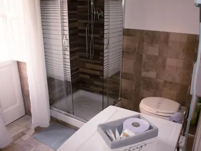 a bathroom with a toilet and a glass shower at Pacini Deluxe Apartment in Palermo