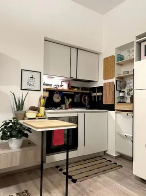a kitchen with white cabinets and a table in it at Carducci apartment in Palermo