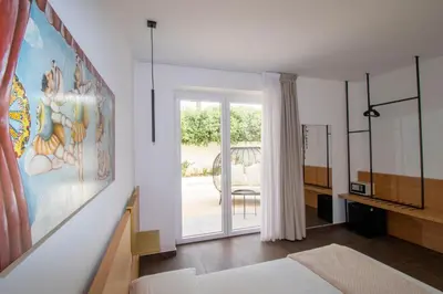 a bedroom with a large painting on the wall at Hotel Arte Mare in San Vito lo Capo