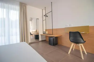 a bedroom with a bed and a desk and a chair at Hotel Arte Mare in San Vito lo Capo