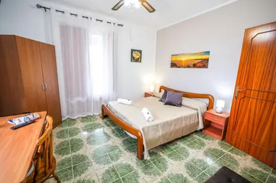 a bedroom with a bed and a table and a desk at B&B Giardino dei Cedri in Trabia