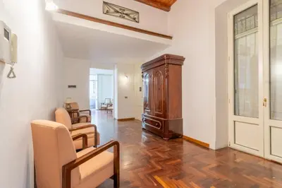 a living room with a wooden floor and a door at MARIANO APARTMENT Palermo in Palermo