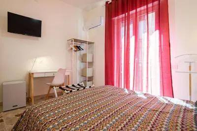 a bedroom with a bed and a red curtain at Il gabbiano a Ballarò in Palermo