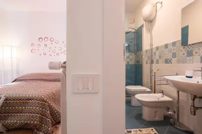 a bathroom with a bed and a sink and a toilet at Il gabbiano a Ballarò in Palermo