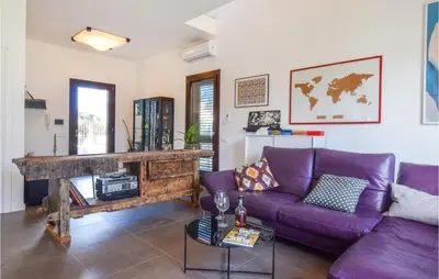 a living room with a purple couch and a fireplace at Gorgeous Home In Trabia With Wifi in Trabia