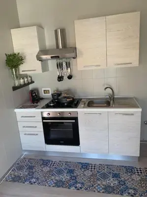a kitchen with white cabinets and a stove top oven at D'Kasa Mia Capaci in Capaci