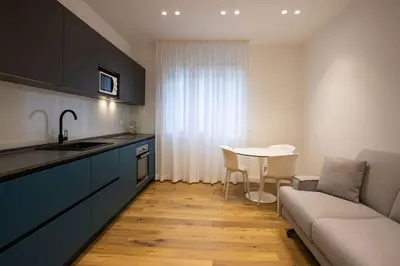 a kitchen with a table and a couch and a kitchen with a table at Luxury Libertà in Palermo