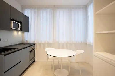 a small kitchen with a white table and chairs at Luxury Libertà in Palermo